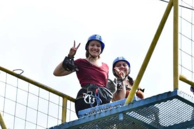 girls making peace signs about to bungee jump