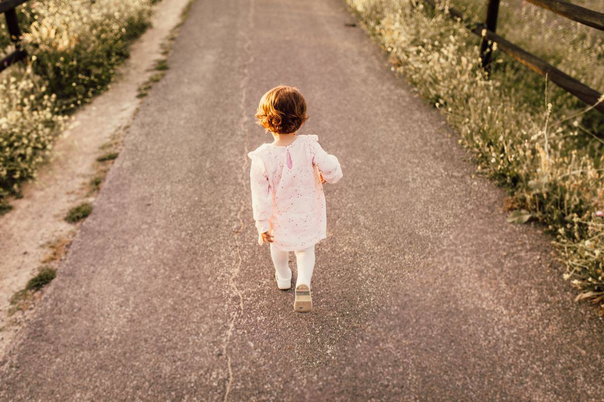 girl-wearing-white-clothes-walking-on-pavement-road-