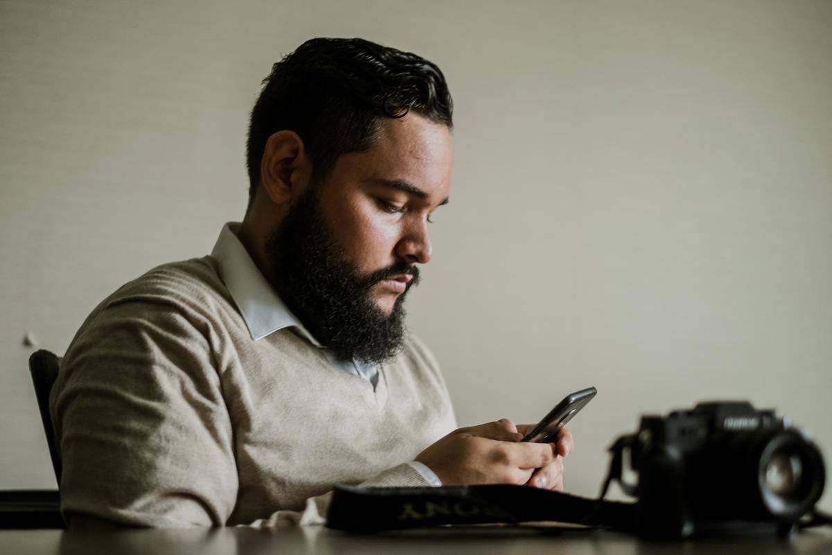 man-with-facial-hair-holds-smartphone texting