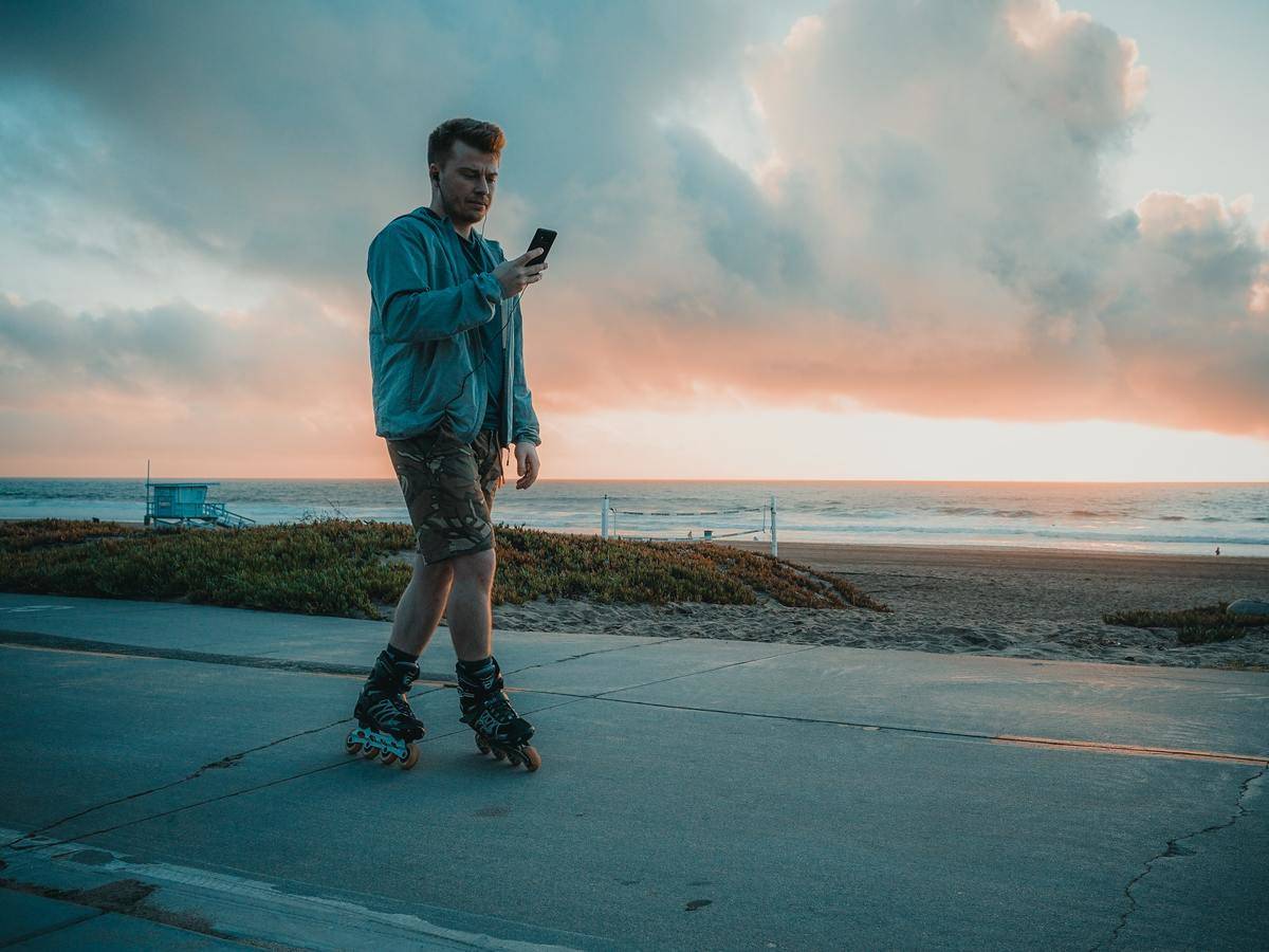 a-man-wearing-roller-blades-while-using-smartphone-