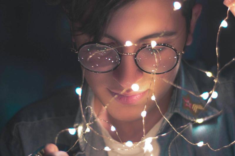 photography-of-man-wearing-eyeglasses and holding string lights