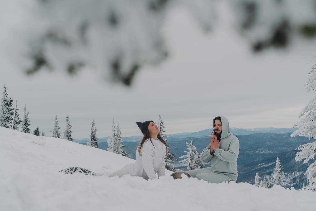 couple doing yoga in cold-snow-healthy-landscape-