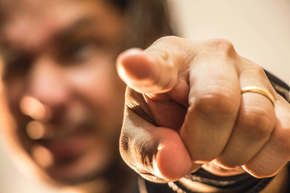 angry man pointing with wedding band on his finger