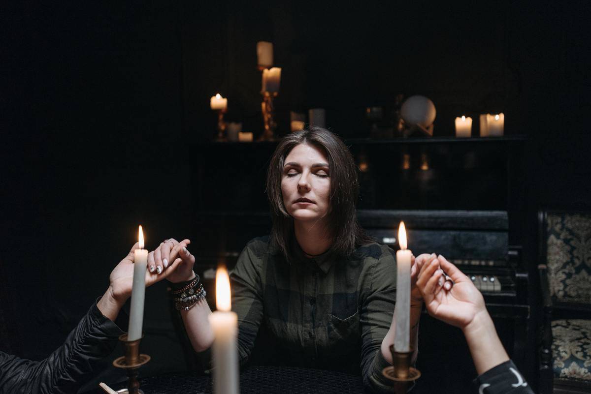 woman-in-gray-long-sleeve-shirt-holding-lighted-candles-