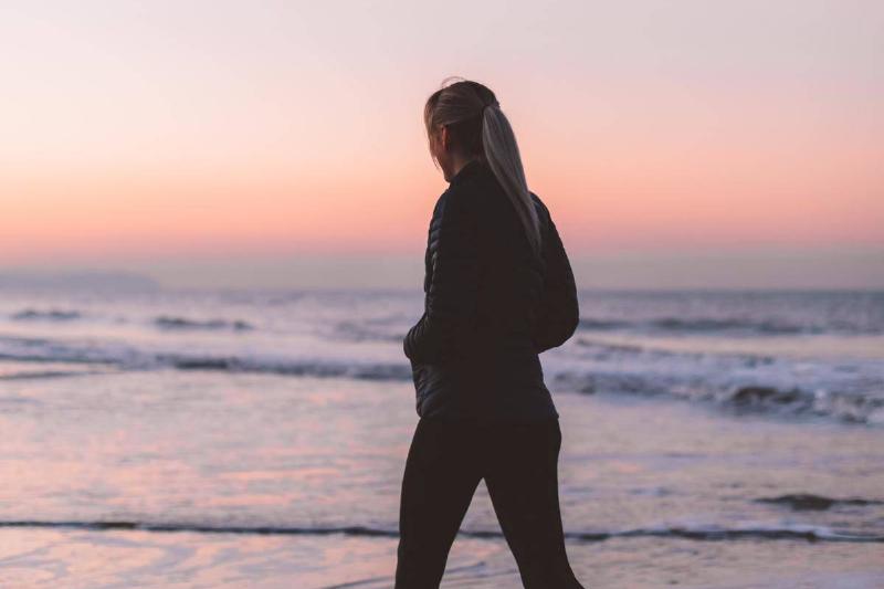 woman walking at sunset on beach