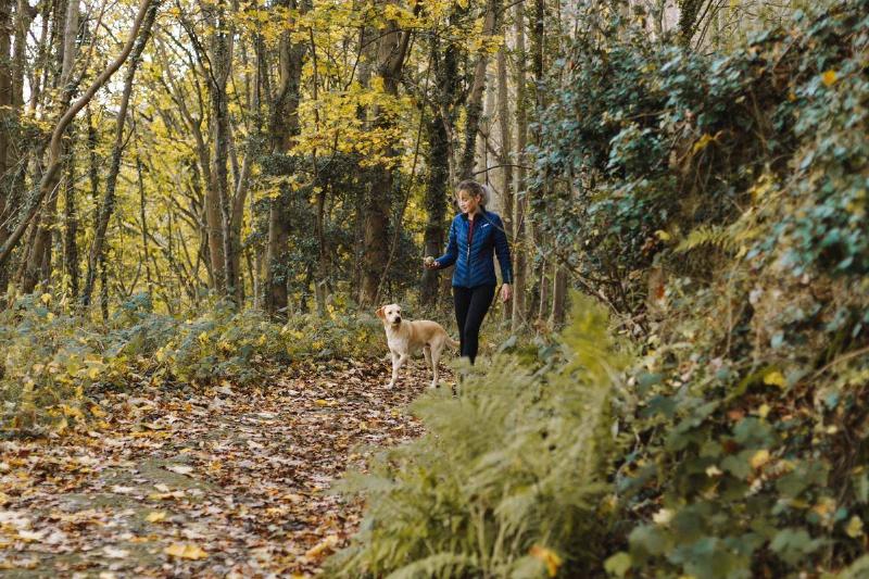 woman-and-dog-walking-at-woods