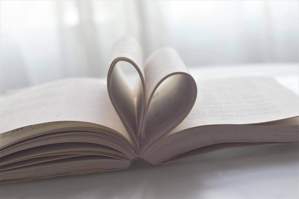 A book opened and its center pages folded inwards to make a heart shape.