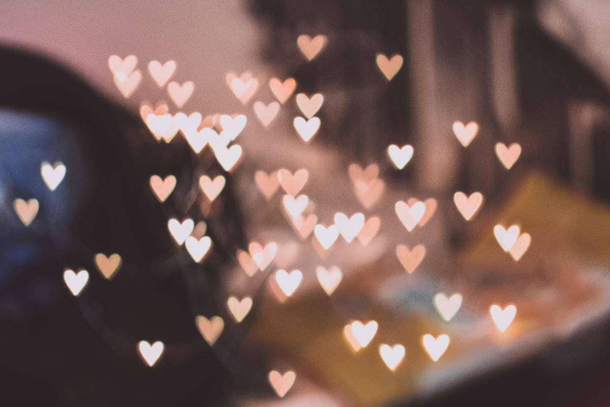 A multitude of small pink heart lights diffusing across a blurry background.