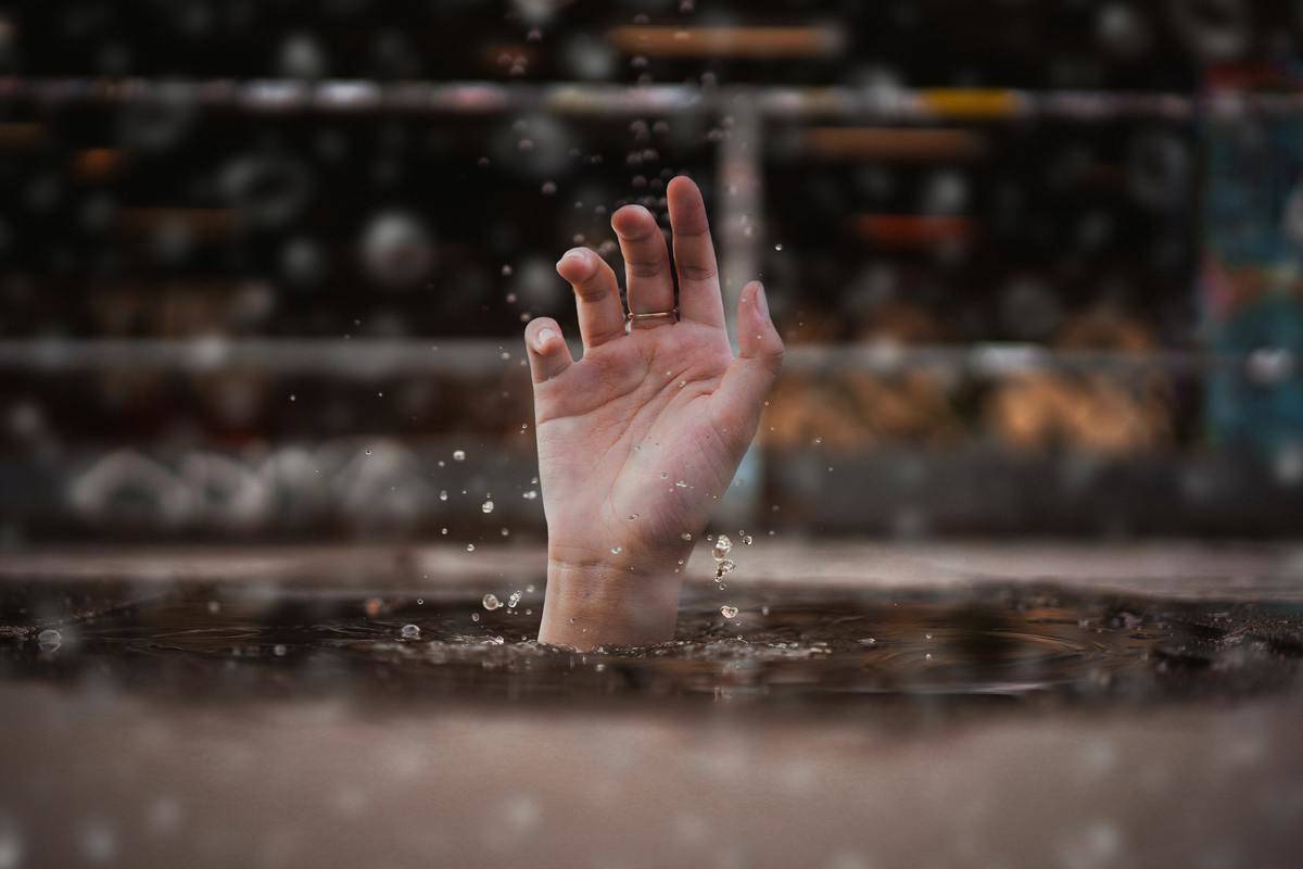 A hand reaching up out of the water.
