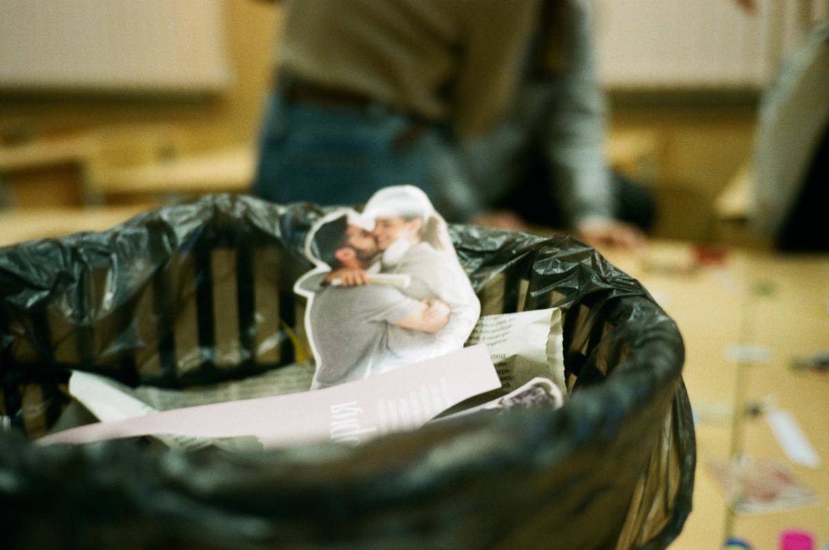 A photo cutout of a couple embracing placed in a garbage can.