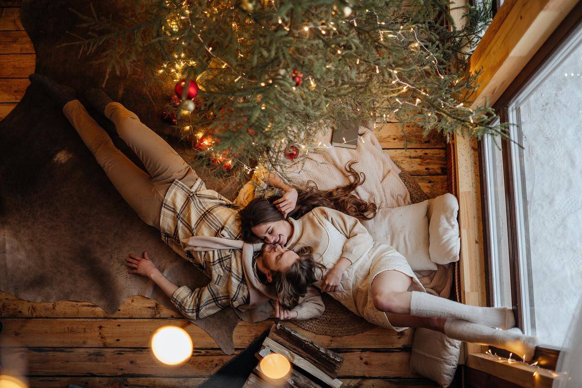 couple-lying-on-carpet-and-christmas-tree