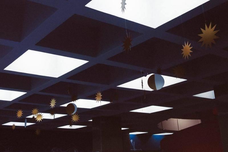 A ceiling decorated with paper suns and moons.
