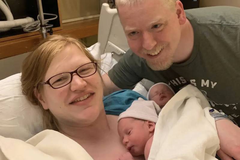 parents with twins at birth at hospital bed
