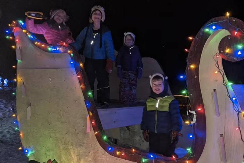 kids on christmas sleigh with lights