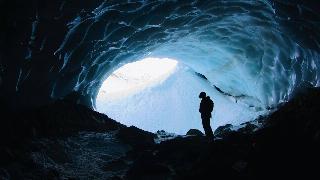 silhouette-photo-of-person-standing-in-cave