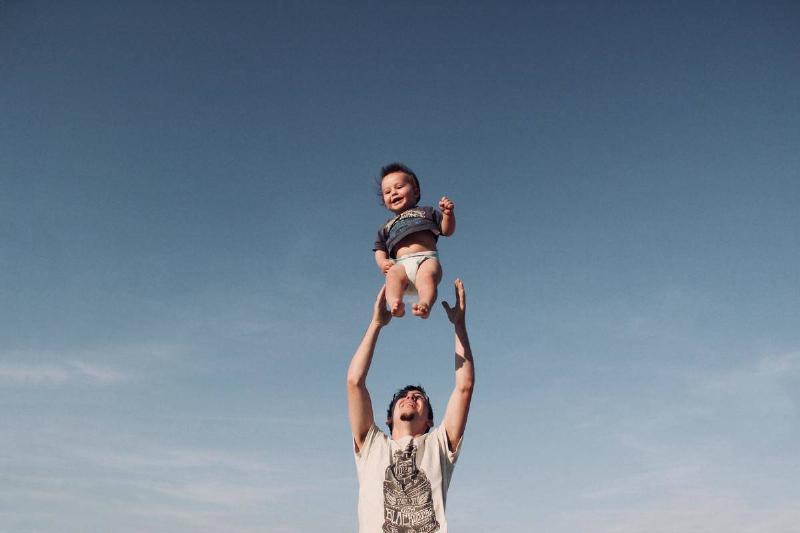hoto-of-man-in-raising-baby-under-blue-sky
