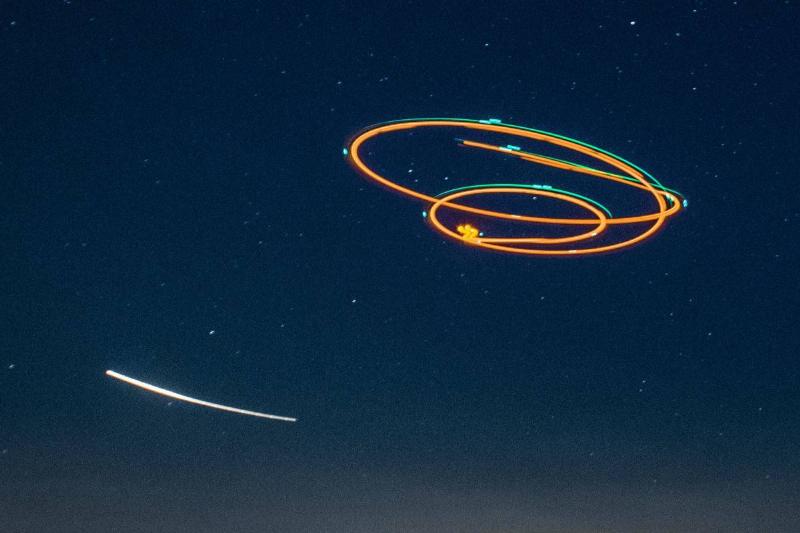 A time-lapse photo of bright, artificial lights in the night sky, spun in a circular shape.