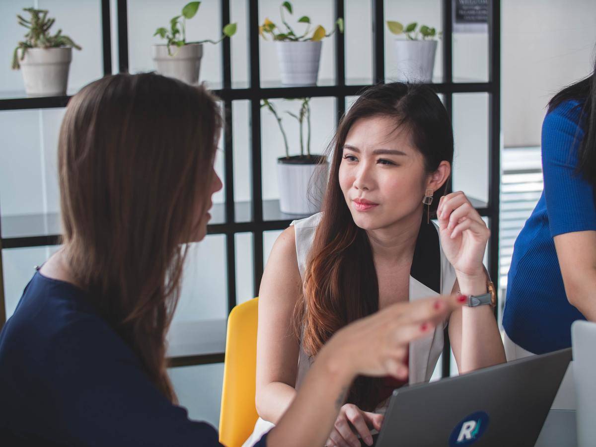 Two woman at a table having a conversation.