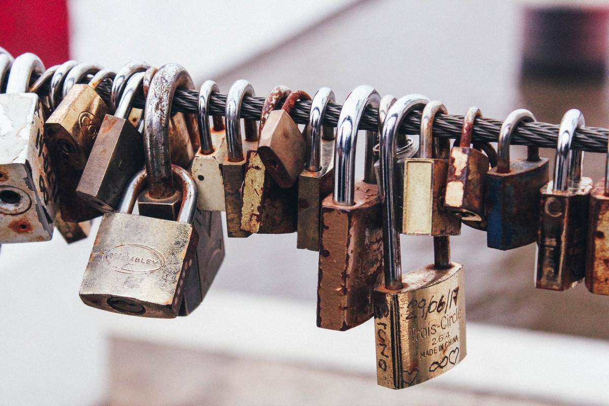 A row of padlocked affixed on a cable.