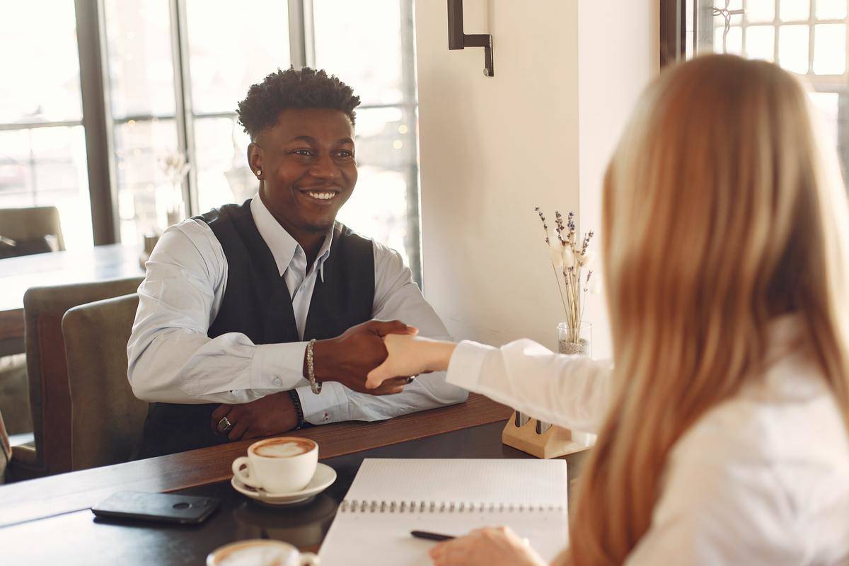 A man and woman shaking hands at an interview.