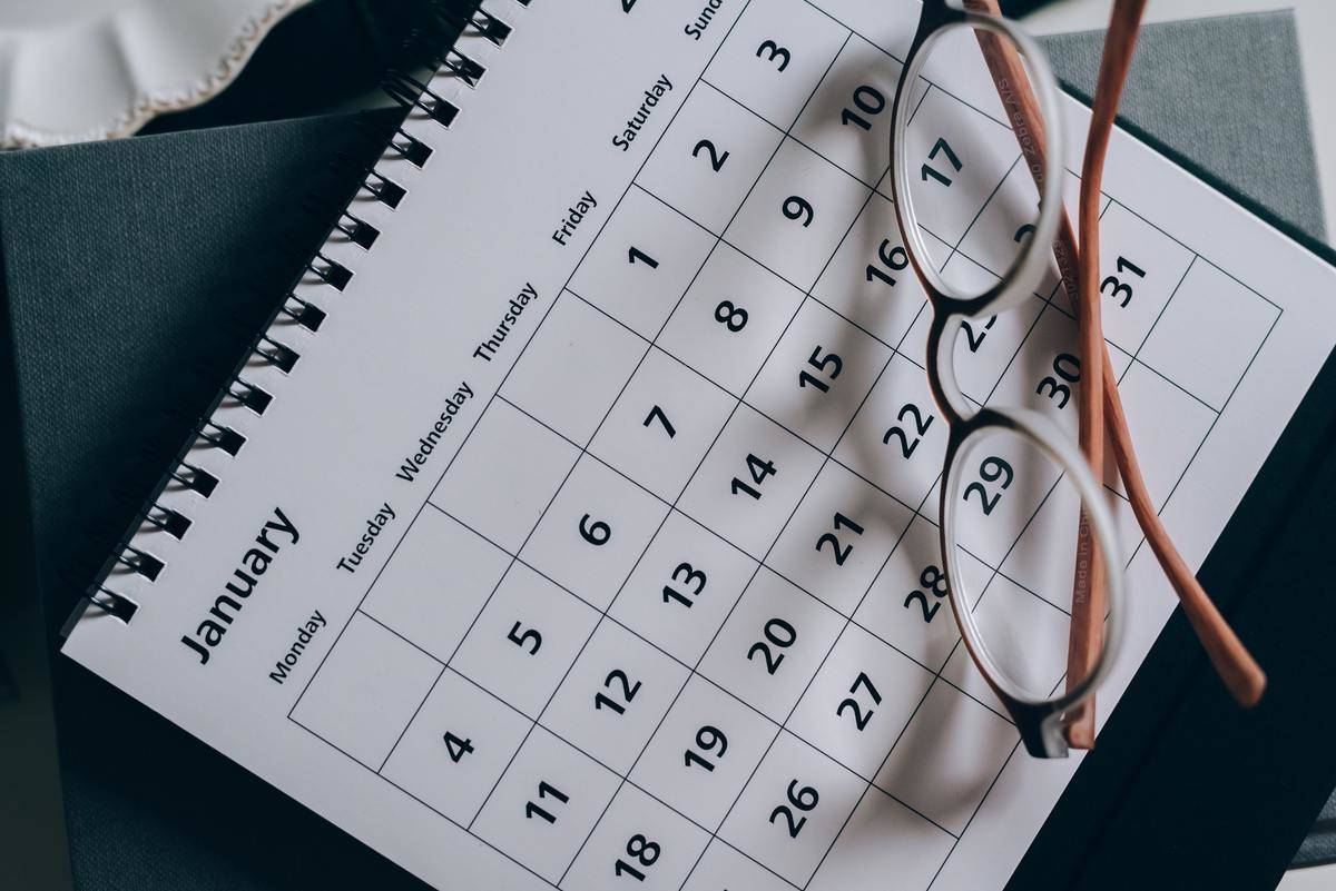 A calendar with a pair of glasses atop it.