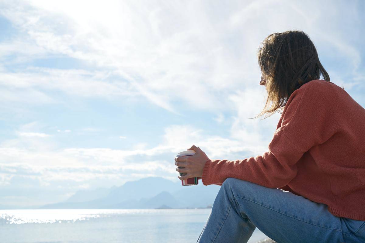 erson-sitting-in-front-of-body-of-water-