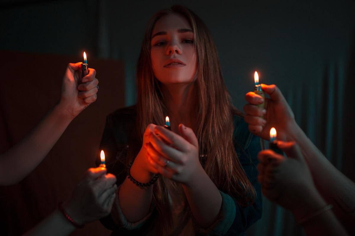 woman-holding-disposable-lighter surrounded by others holding lighters