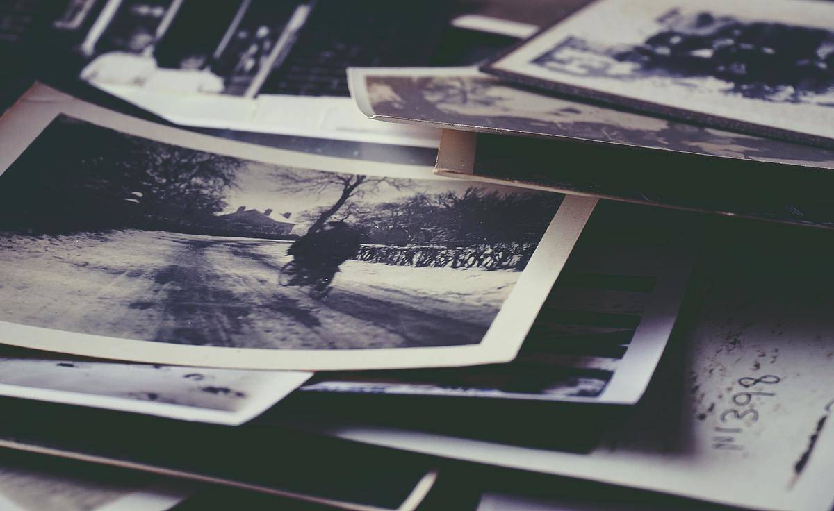 A scattered stack of black and white printed photos.
