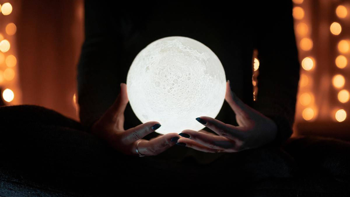 woman's hands holding white crystal ball