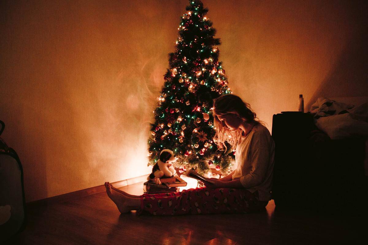 hoto-of-woman-sitting-near-the-christmas-tree- on the floor