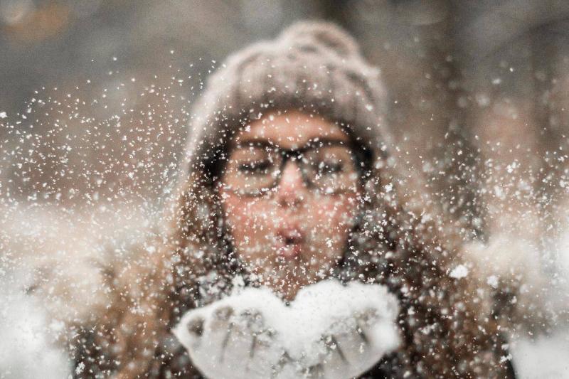 woman-blowing-snow-outdoors