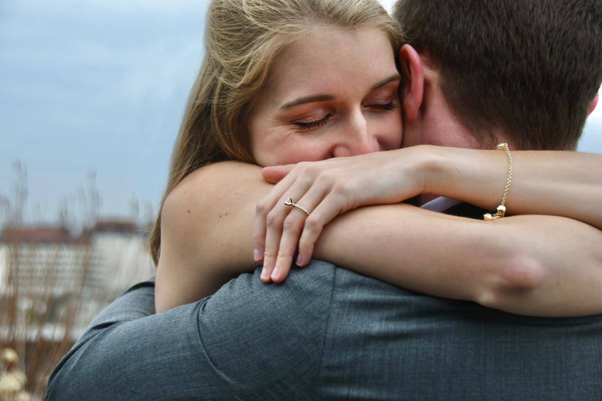 woman hugs man with eyes closed and smiling