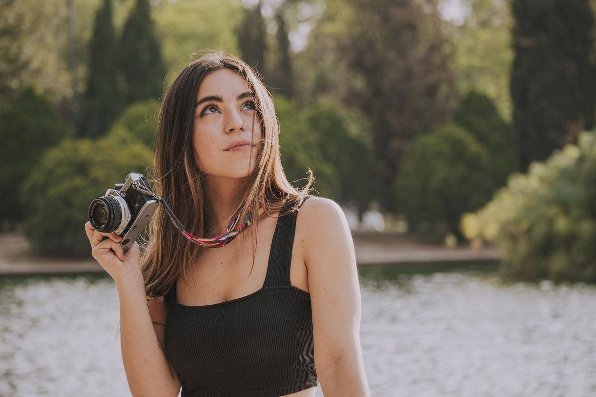 woman looking up while holding her camera