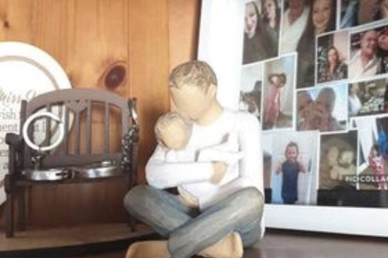 Dad figurine given by postman on shelf by pictures