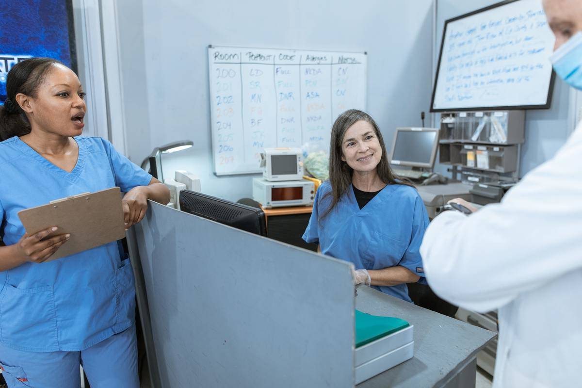 Hospital staff standing around a desk and chatting.