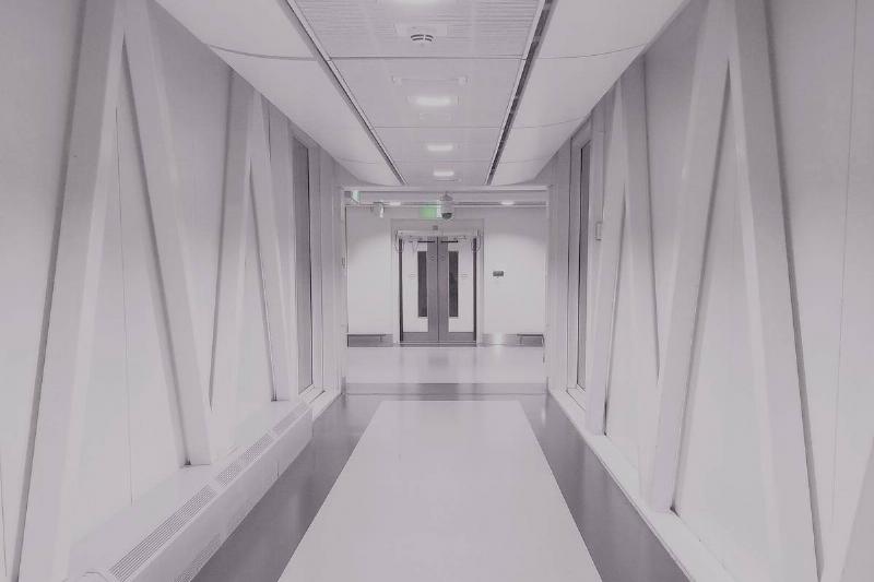 A bright white hallway with a door at the end.