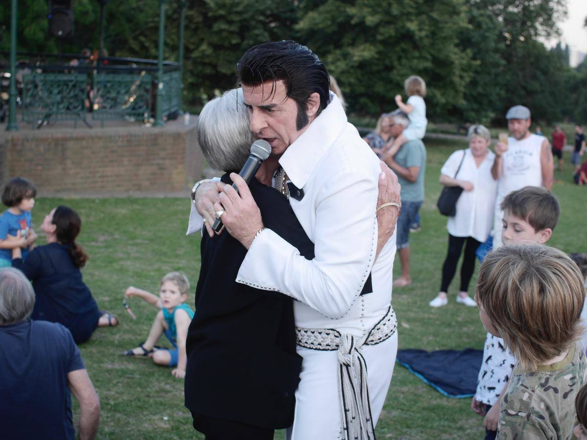 A woman hugging an Elvish impersonator in a park.