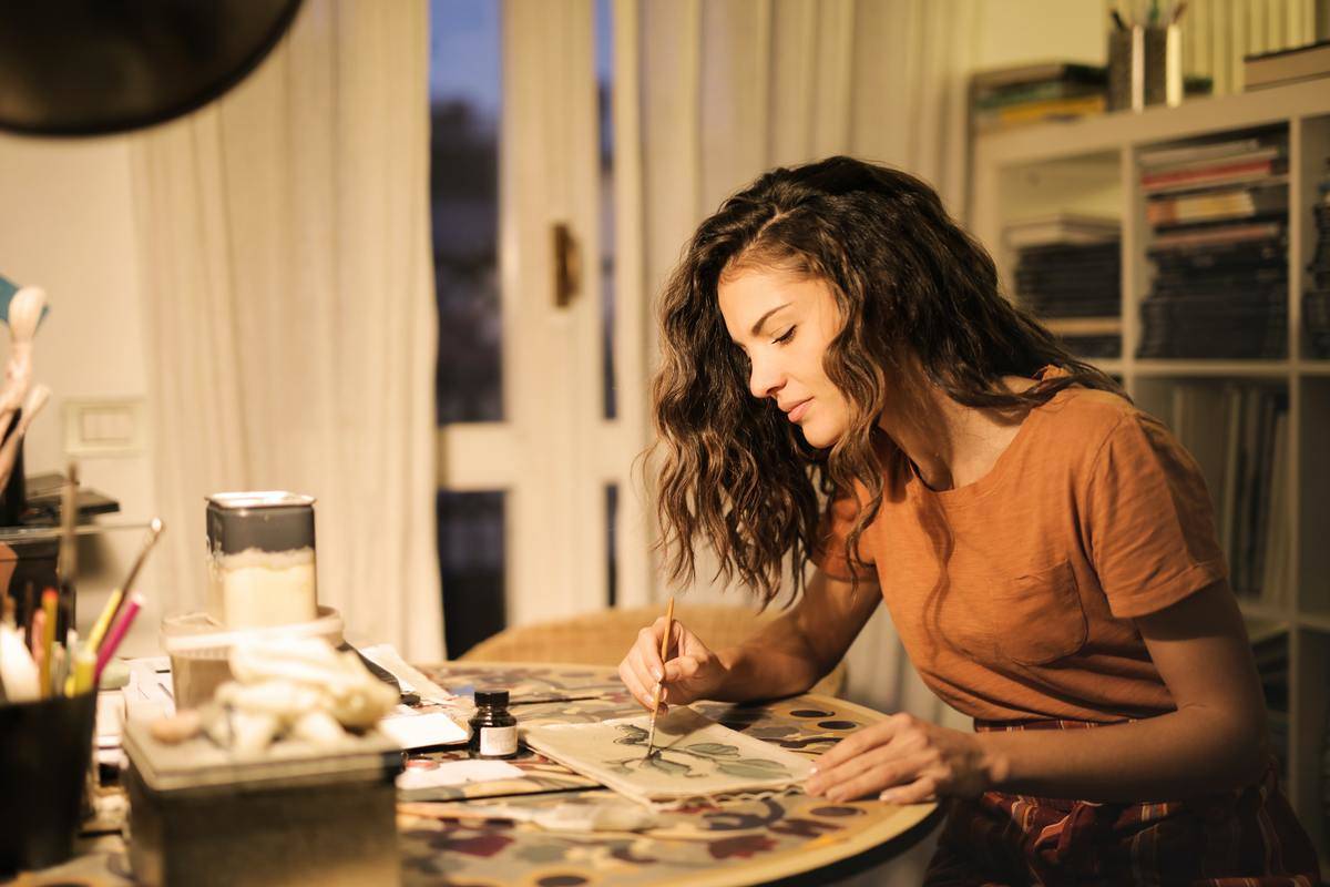 A woman painting on a table.