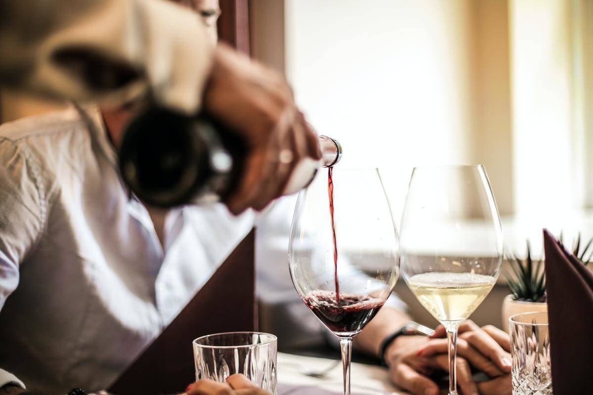 crop-man-pouring-red-wine-in-glass-in-restaurant