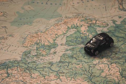 A small toy car placed atop a map, just below the Nordic nations.