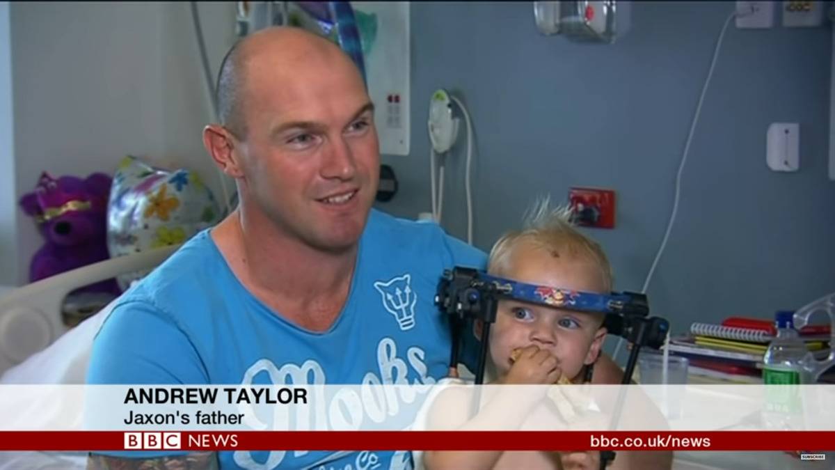 Jaxon's father, Andrew, holding Jaxon as he speaks to BBC News.