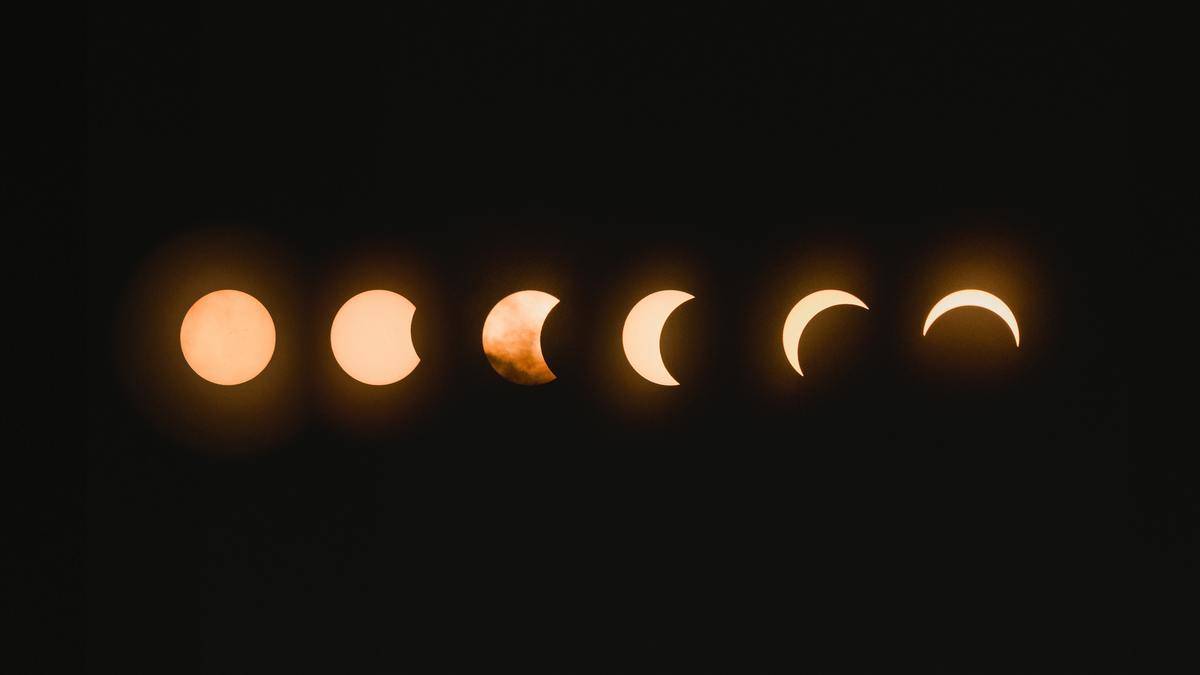 The moon in its many phases against a black sky.