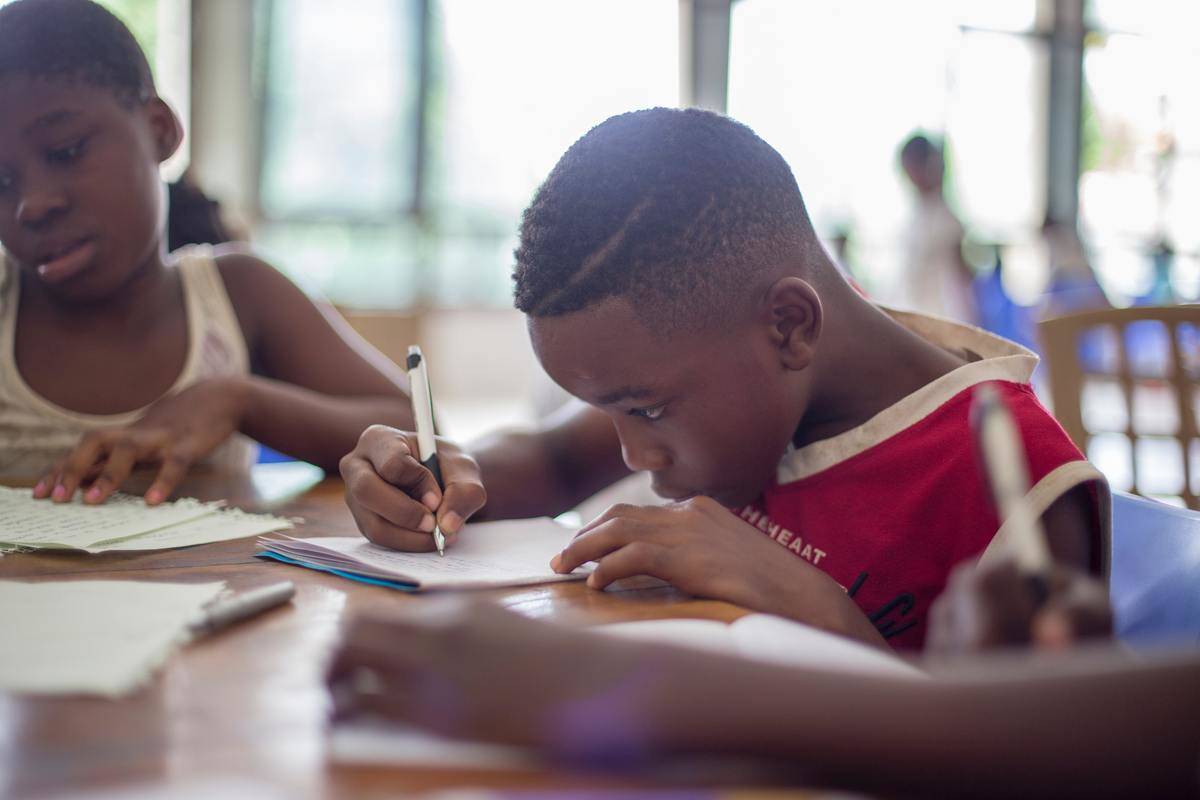 A young boy writing on paper.