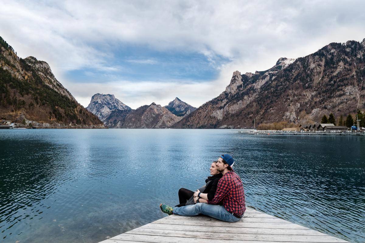 man-and-woman-sitting-on-brown-wooden-dock with nice scenic view