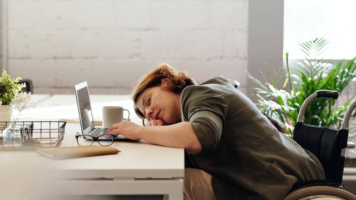 A woman who's fallen asleep at her desk.