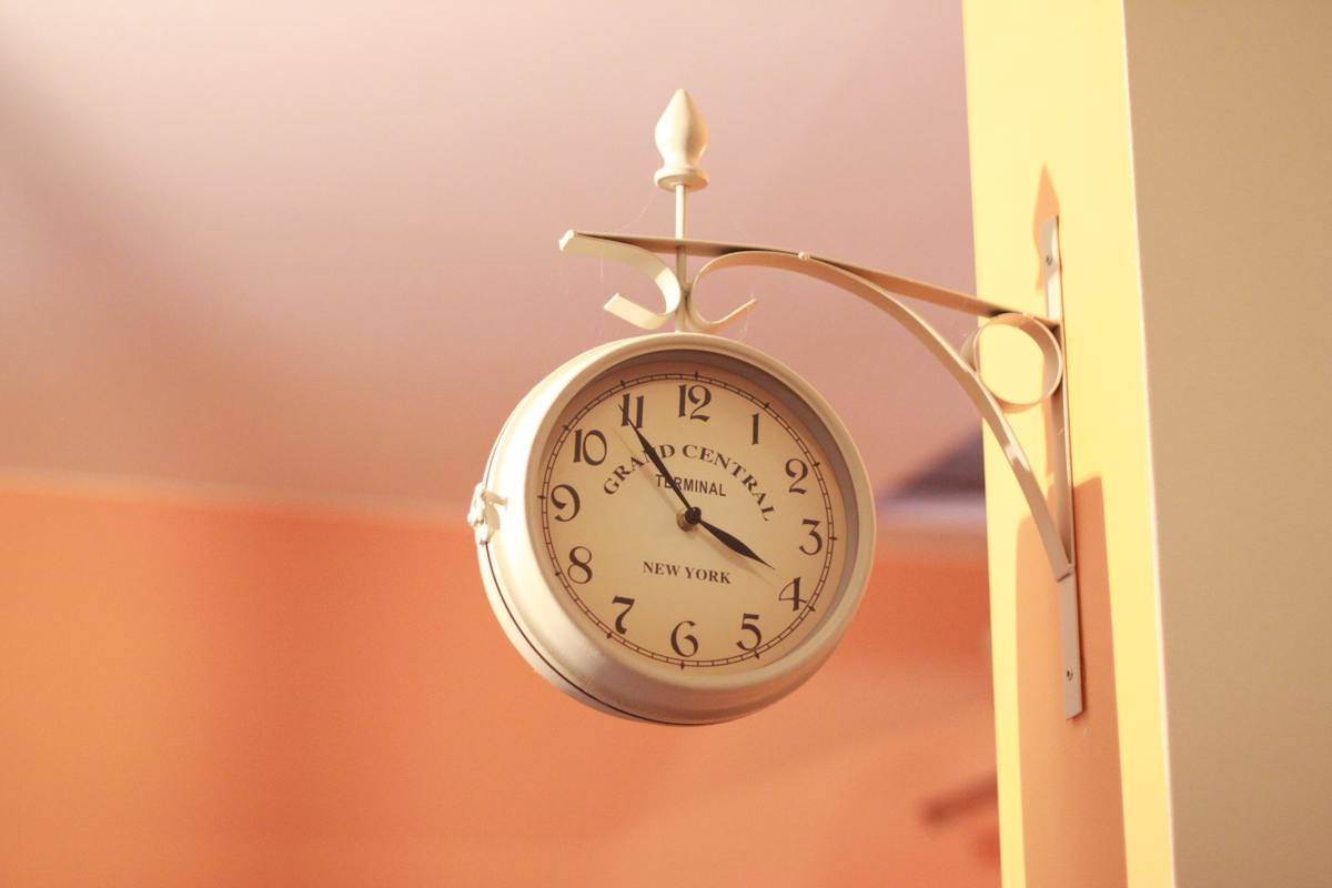 A vintage white clock hung on a wall.