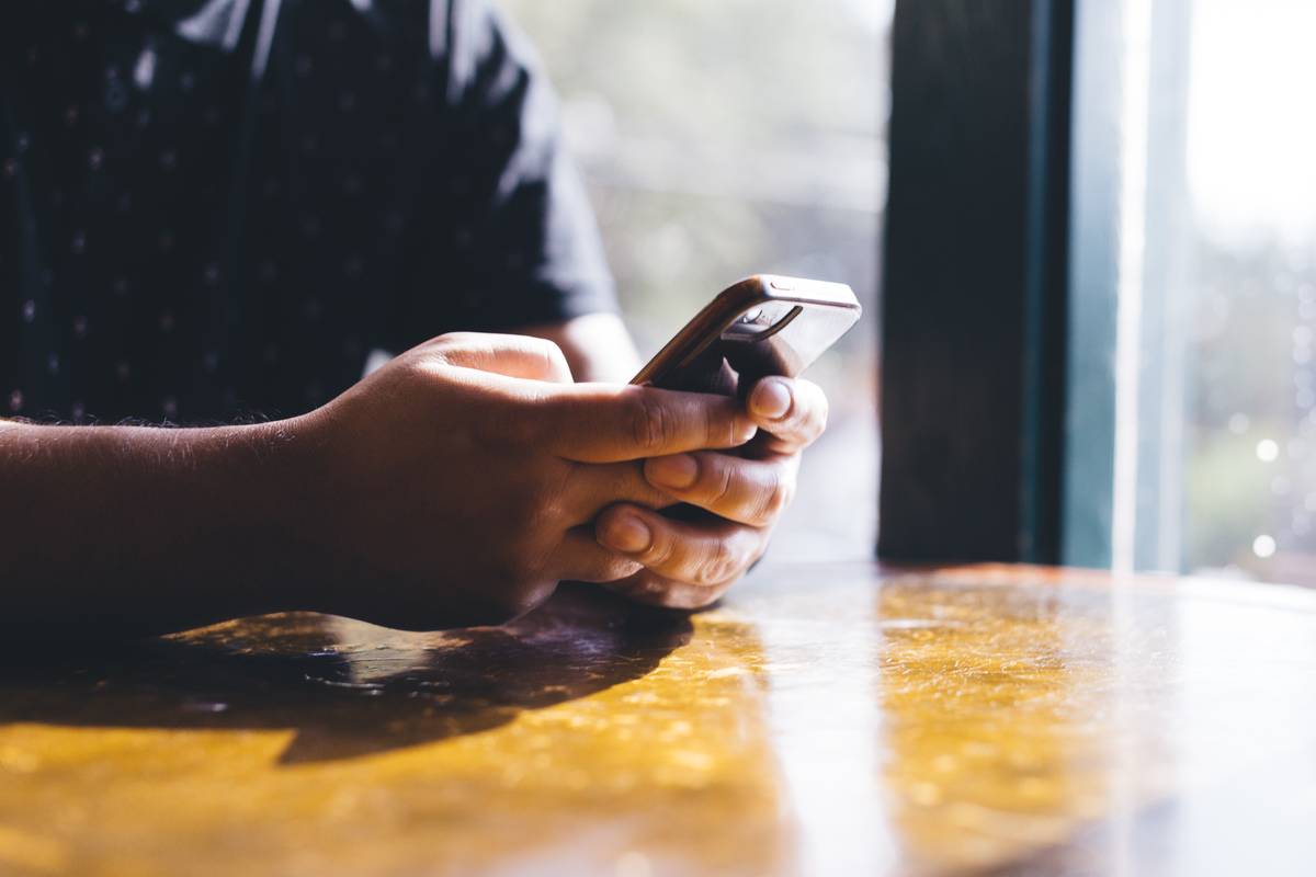 Hands holding a phone, texting.