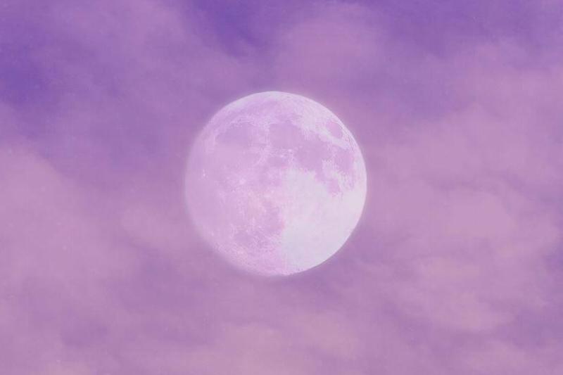 The moon in a purple sky full of clouds and a flock of birds.