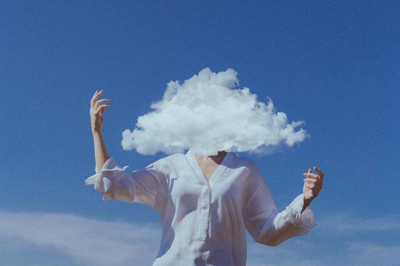 A woman with a cloud covering her face and head.