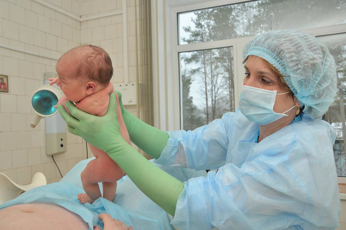 A baby being delivered in the hospital.